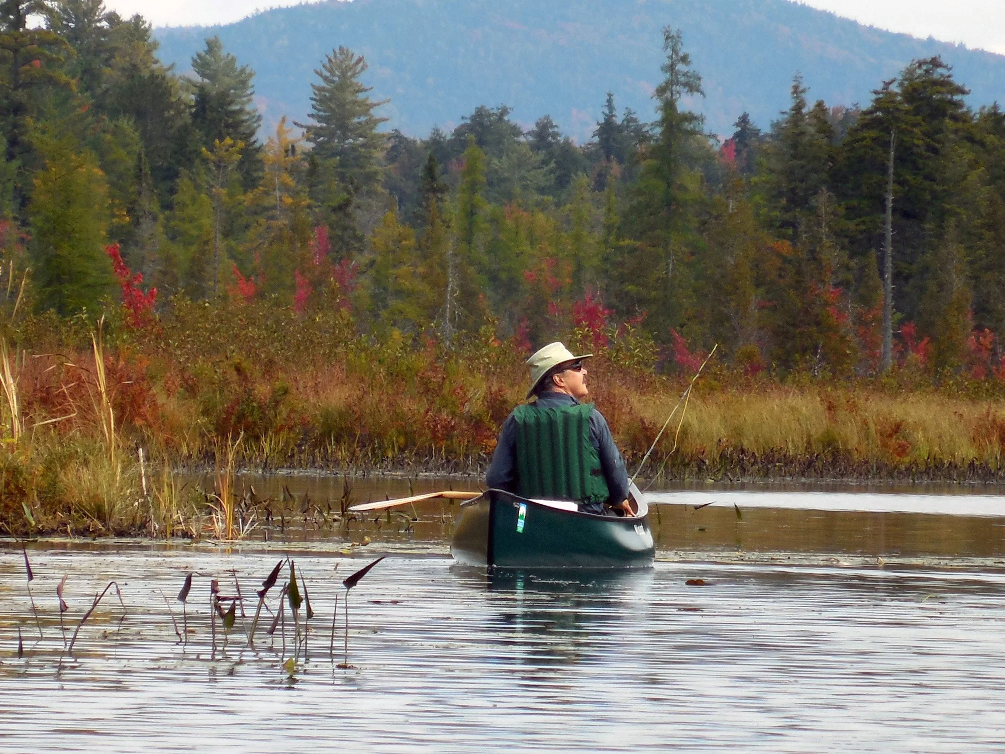 Man fishing from canoe on Raquette Lake in the Central Adirondacks.