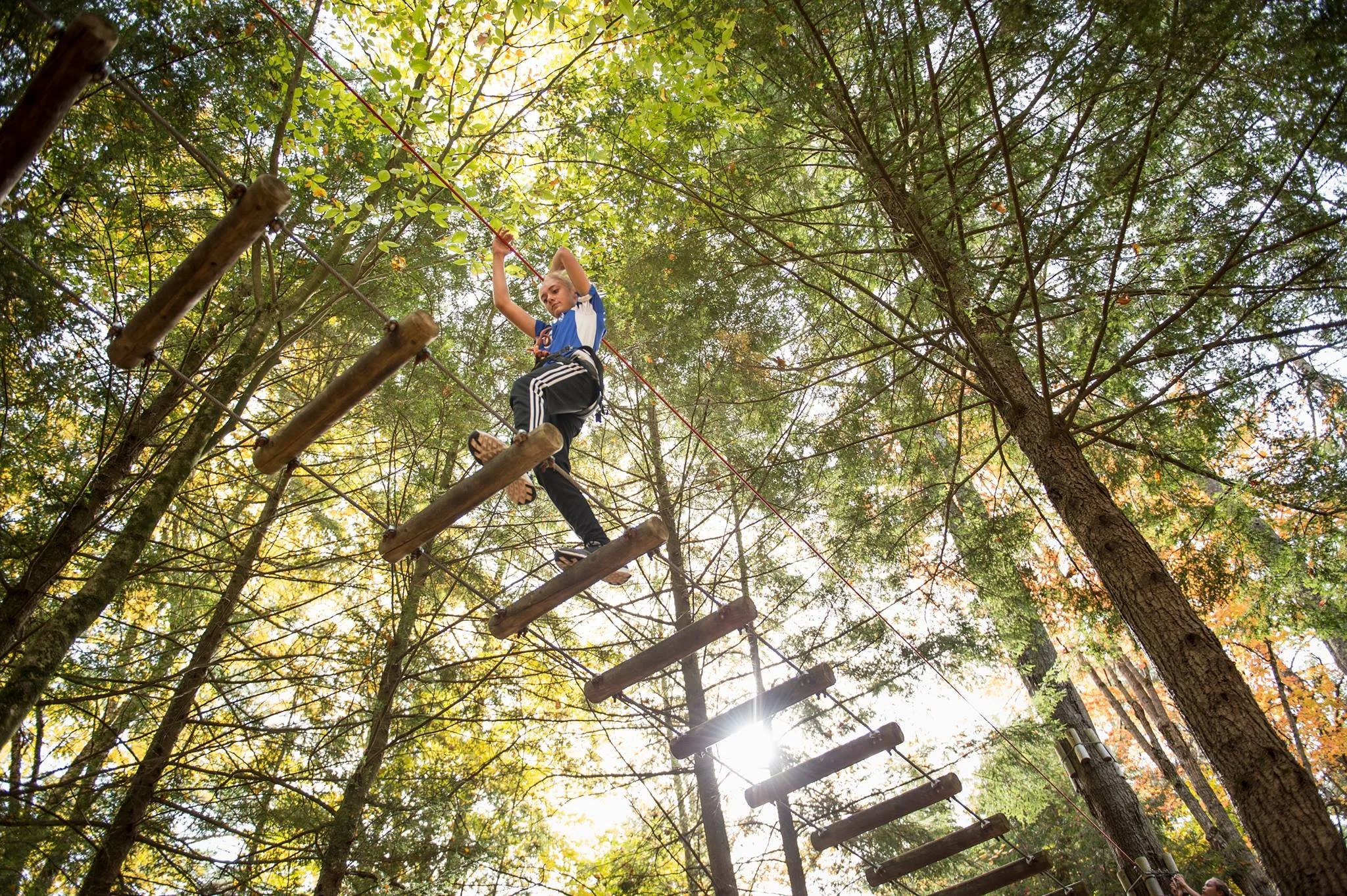 Woman on ropes course at Adirondack Extreme in Lake George.