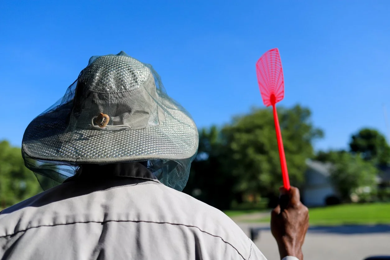 Man with hat and protective netting combatting black fly season in the Adirondacks