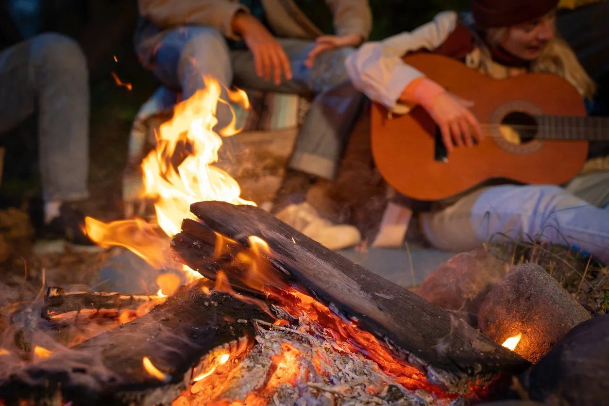 People gathered around an Adirondack campfire.