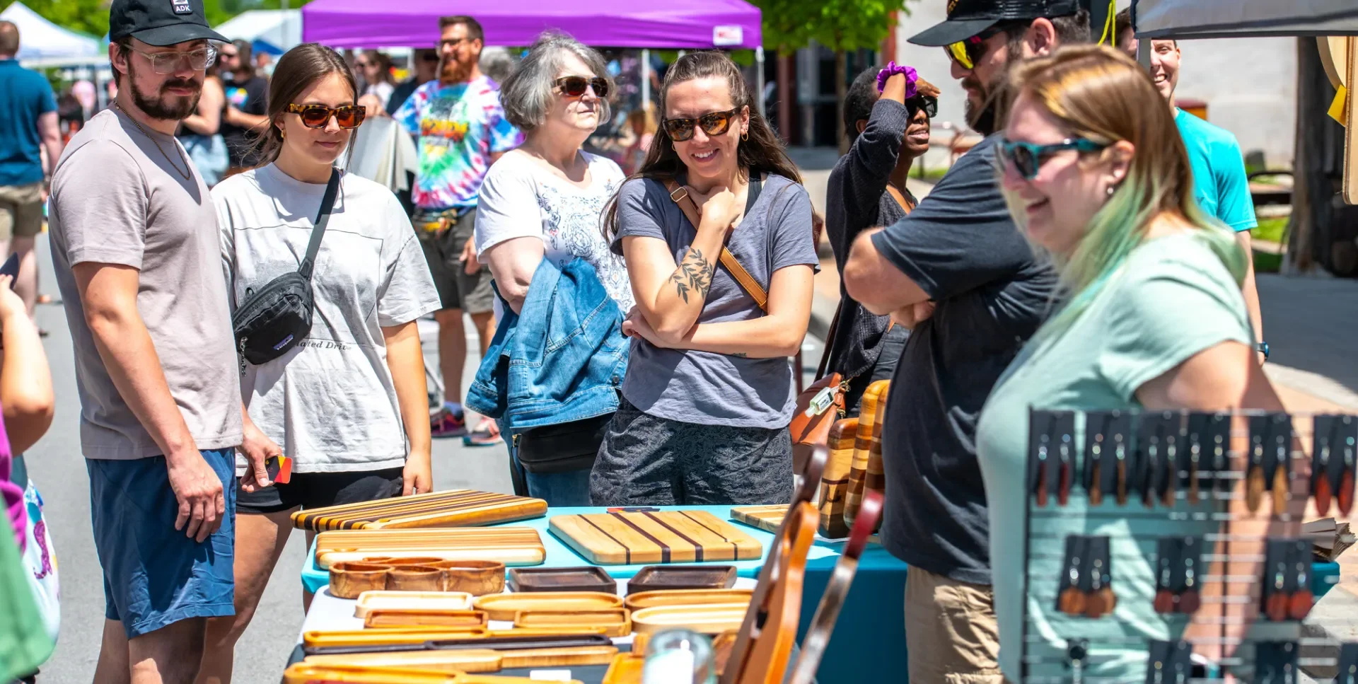 Vendor with hand-crafted wooden objects and cutting boards at Party on Park.
