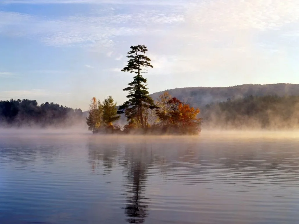 Lake George in morning mist with fall foliage on island.