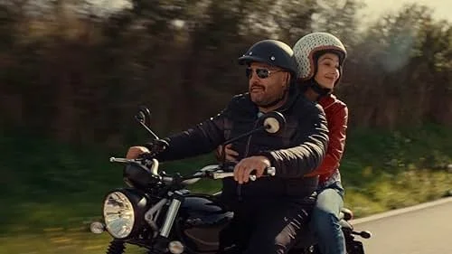 Kevin James and Nicole Grimaudo on a motorcycle in Italy in the movie Solo Mio.