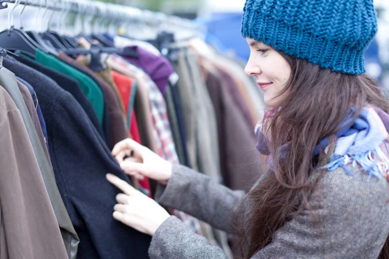 woman shopping at the Great Adirondack Garage sale for vintage clothing .