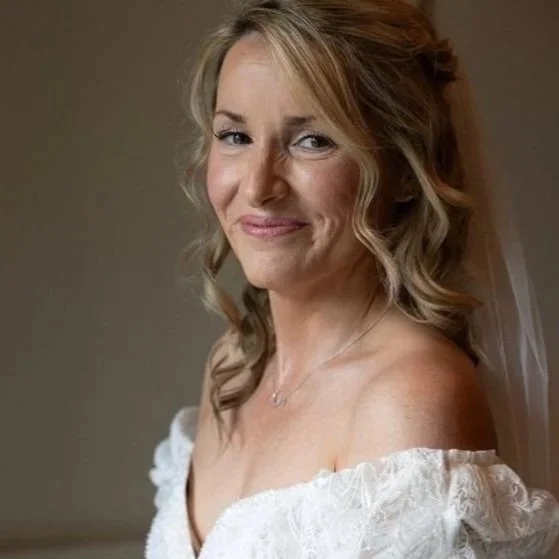 A blonde bride posing on her wedding day. Makeup by @beautybybooms

