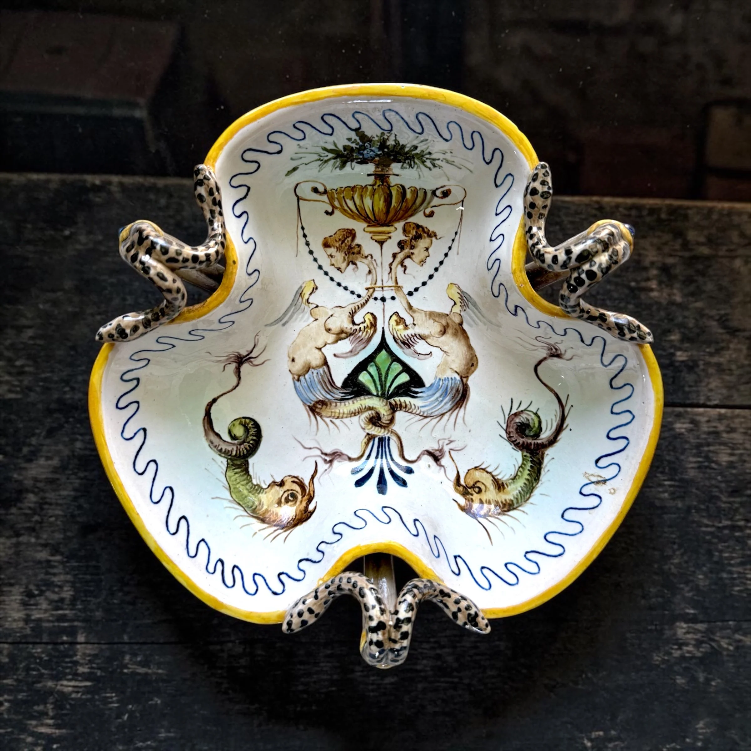 Italian majolica serpent tazza, applied polychrome snake handles, grotesque interior with hybrid figures and sea creatures, trilobate form, cobalt and yellow glaze, c. 19th century — $395