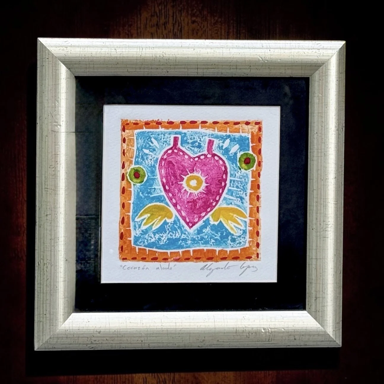 Available on Chairish - Alejandro López Álvarez “Corazón Alado” Signed Hand-Finished Collagraph
Mexican, late 20th to early 21st century, apparently hand-retouched with pastel or pigment, signed and titled by the artist
Artwork 7" × 7", framed 12.5" 