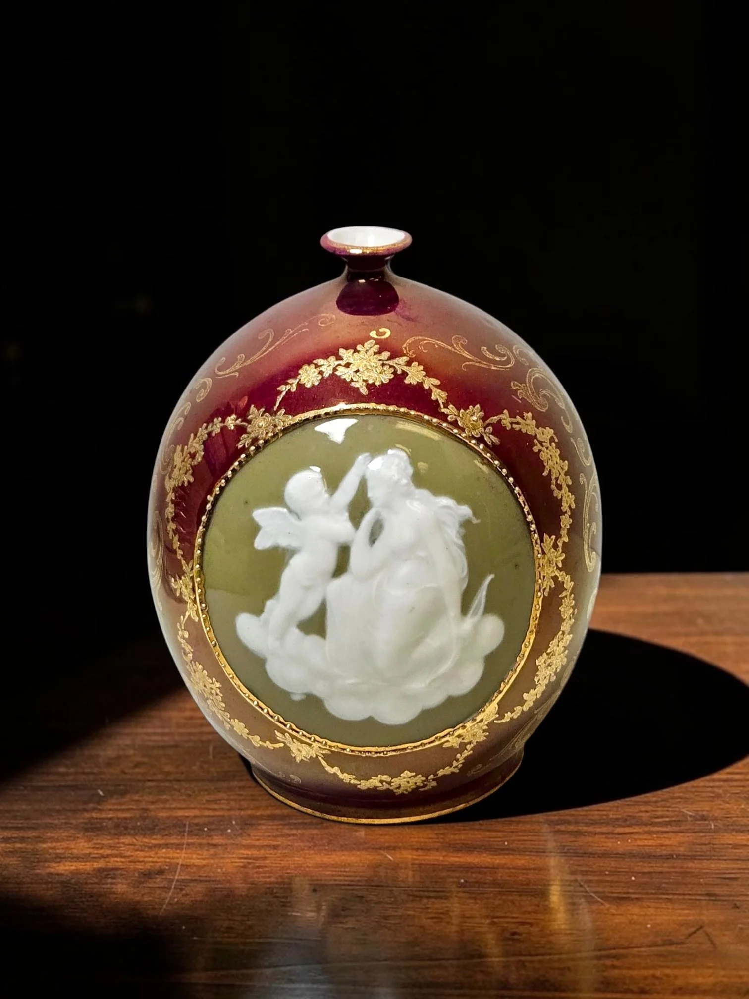 Antique German Royal Pâte-sur-Pâte Porcelain Cabinet Vase, c.1900
German porcelain cabinet vase, circa 1895–1920
Deep burgundy/oxblood ground, olive-green oval reserve, raised white pâte-sur-pâte-style Figural decoration depicting a classical maiden 