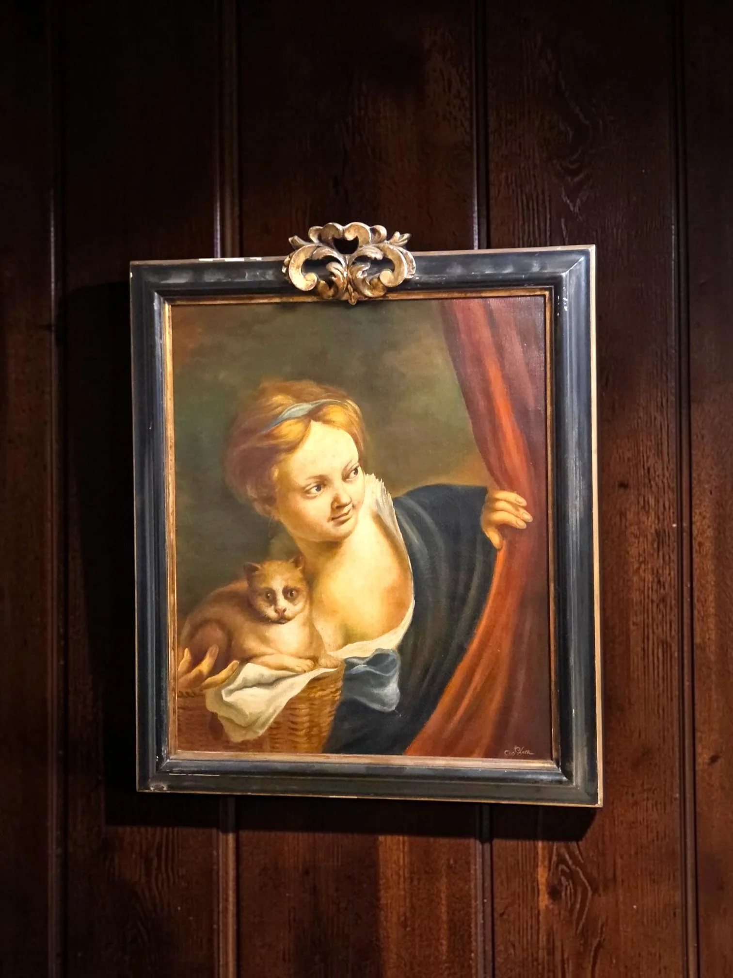 Vintage Chiaroscuro Portrait of a Woman with Cat, Signed Oil on Canvas
Figural oil painting depicting a woman pulling back a red curtain while holding a cat in a basket, dramatic Old Master-inspired composition, signed lower right but artist not yet 