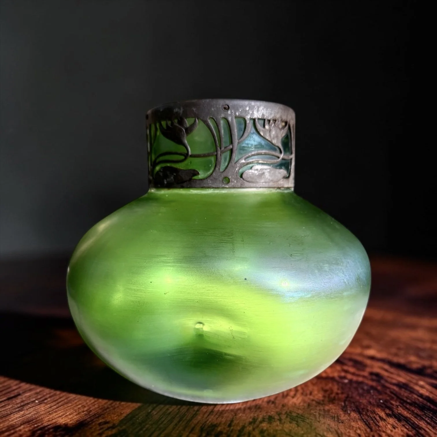 Carl Stölzle Art Nouveau Iridescent Glass Vase, Circa 1905
c. 1900–1910,
Squat globular form with luminous green-gold-blue surface, pierced silvered ferrous-metal floral collar, hand-blown with ground and polished pontil, unsigned, 
6.5" H x approx. 