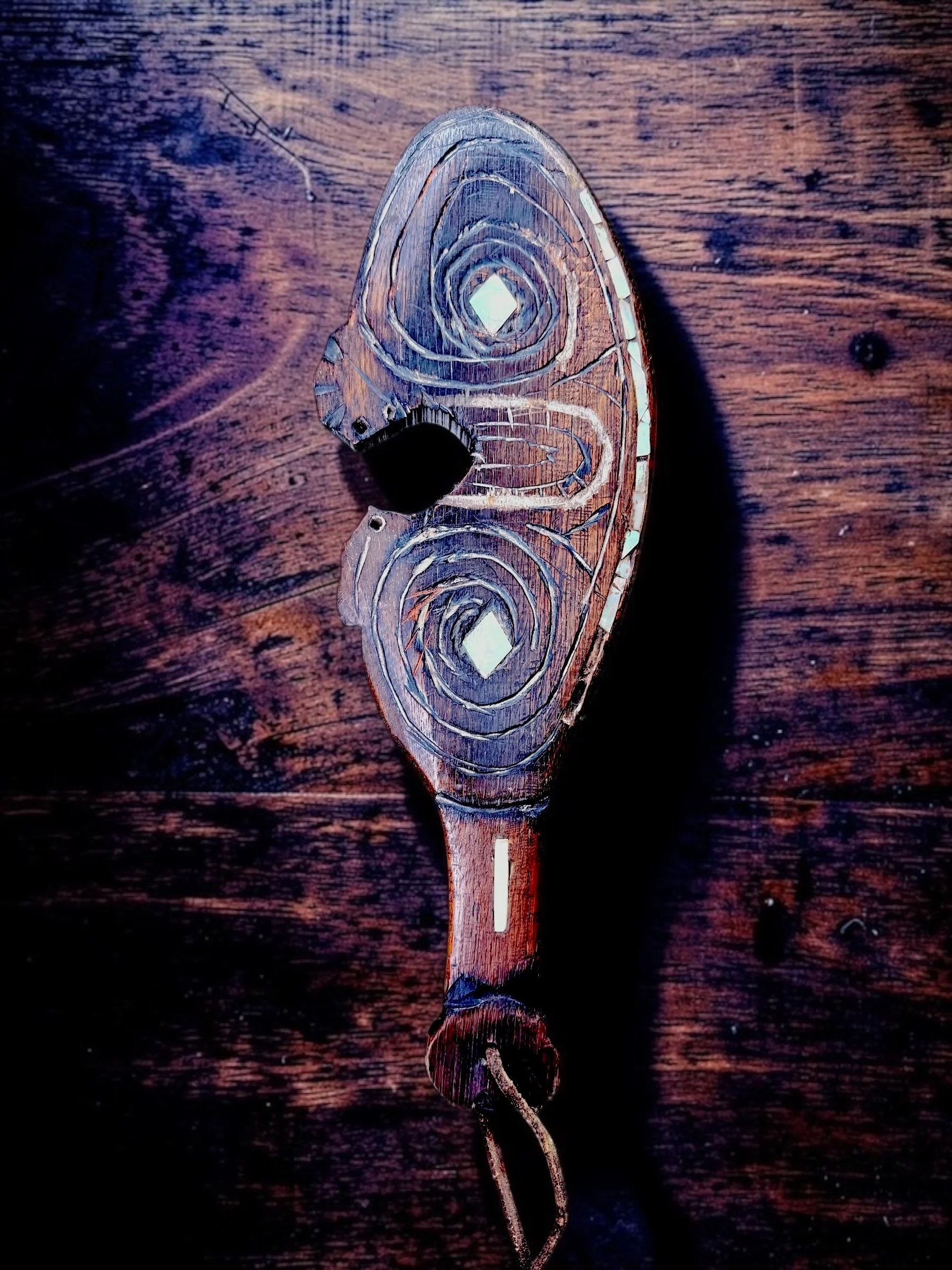 Circa 1880–1930 Māori Carved Wood Wahaika with Pāua Shell Inlay
Traditional short-club weapon form, deeply carved double-sided spiral decoration, pāua shell inlay, leather wrist thong, one missing shell inlay, old central loss and repair, age-related