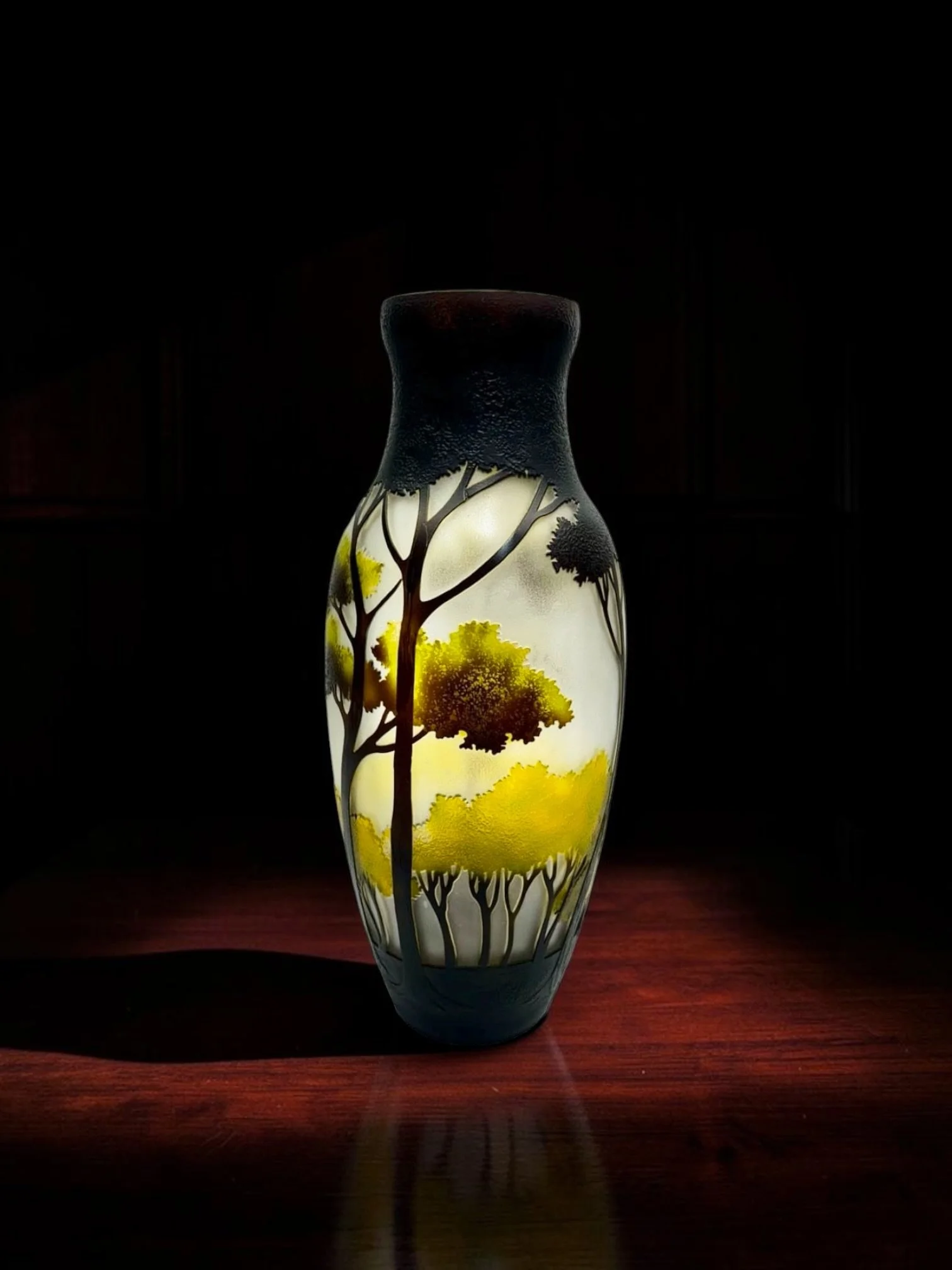 Art Nouveau Revival Cameo GlassLandscape Vase in the Gallé Style

Gallé-style cameo art glass vase, late 20th century, layered scenic landscape decoration with tall silhouetted trees and yellow-green foliage, frosted pale ground, deep charcoal and br
