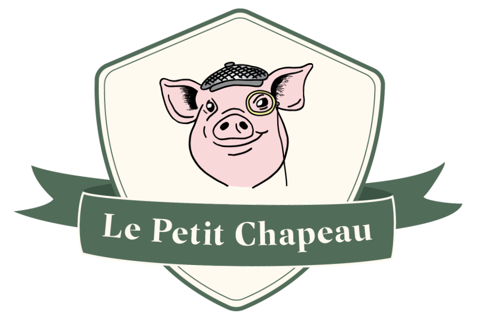 Emblem: Designed to communicate heritage, tradition, and a touch of modern whimsy, Le Petit Chapeau's primary brand mark integrates a vintage butcher crest with a line drawing of a personified pig.

• Typography: Featuring the expressive, book-inspir