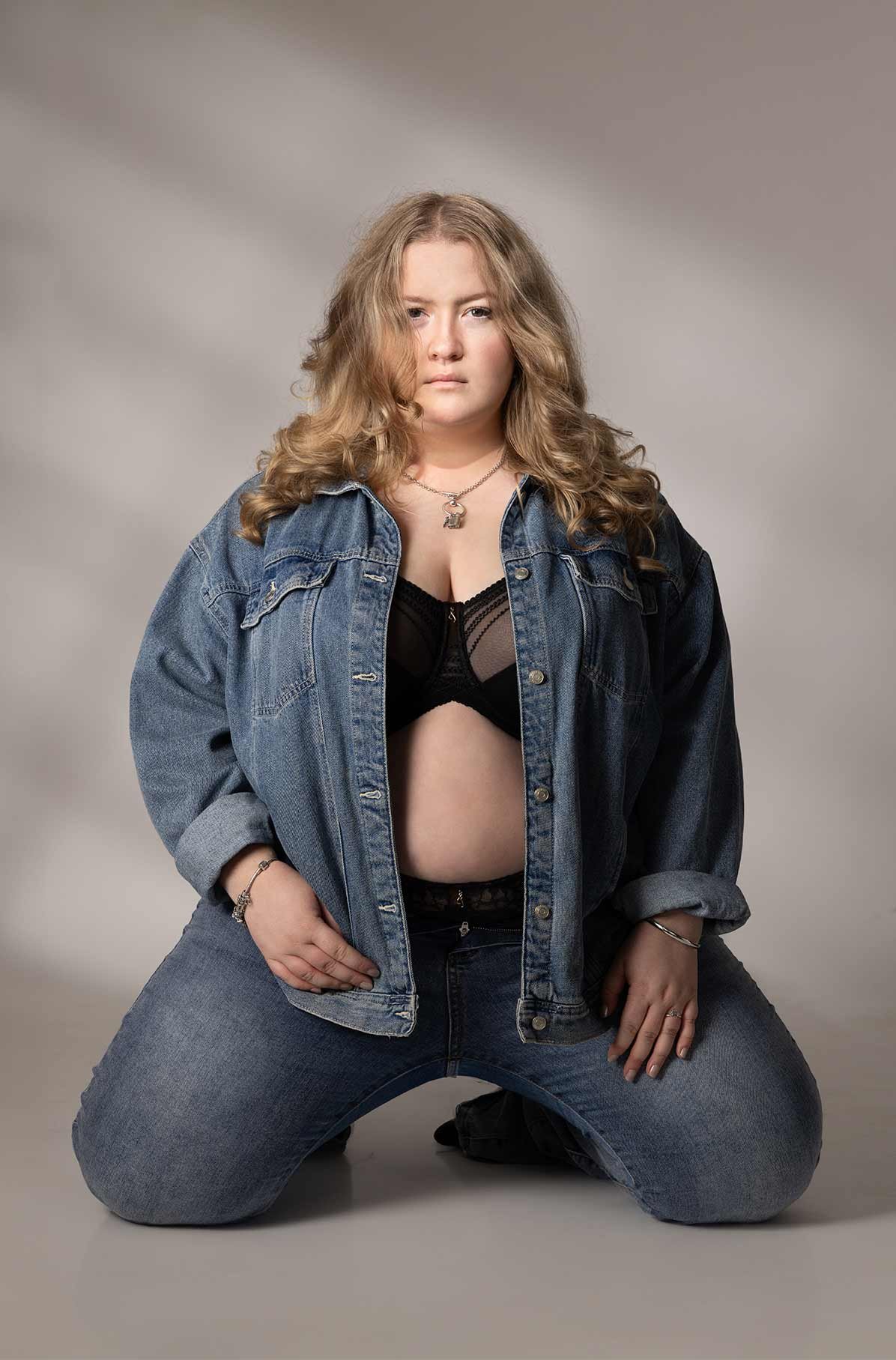 Confident boudoir portrait wearing denim jacket
