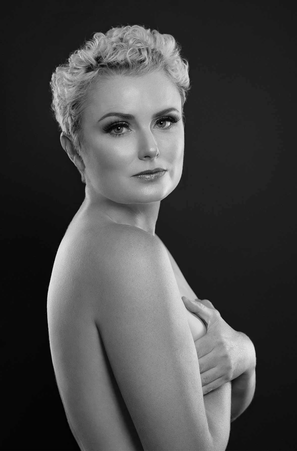 Studio boudoir shot in black and white on a black background
