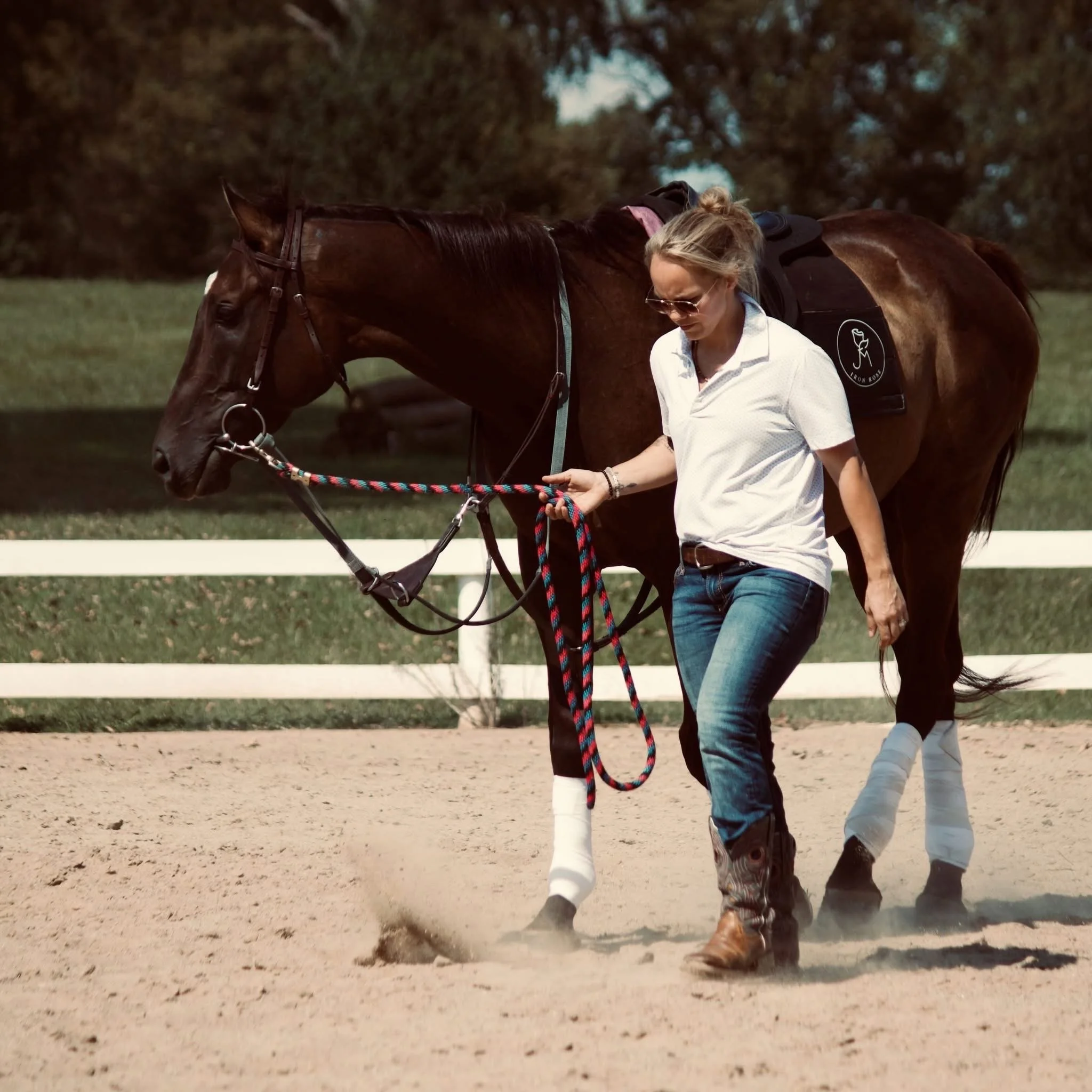 Sunny Bayne, rider fitness coach and co-founder of Sol Fitness, walking with a horse