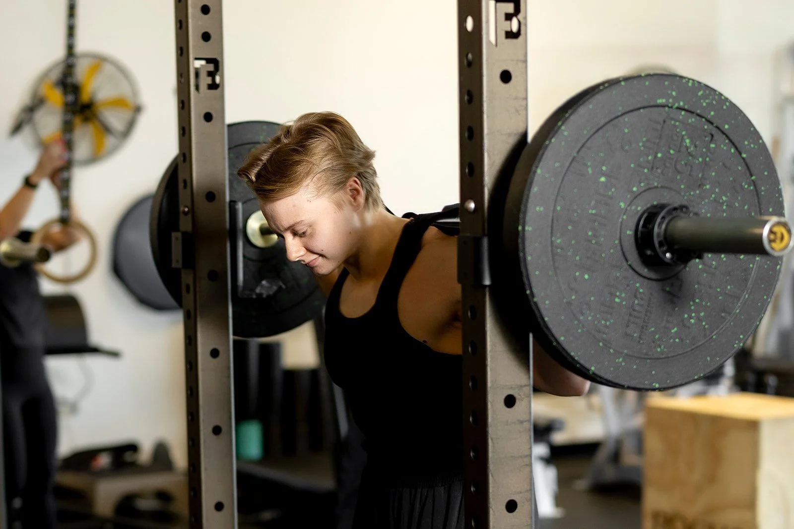 Macy Thacker, personal trainer at Sol Fitness, performing a barbell back squat