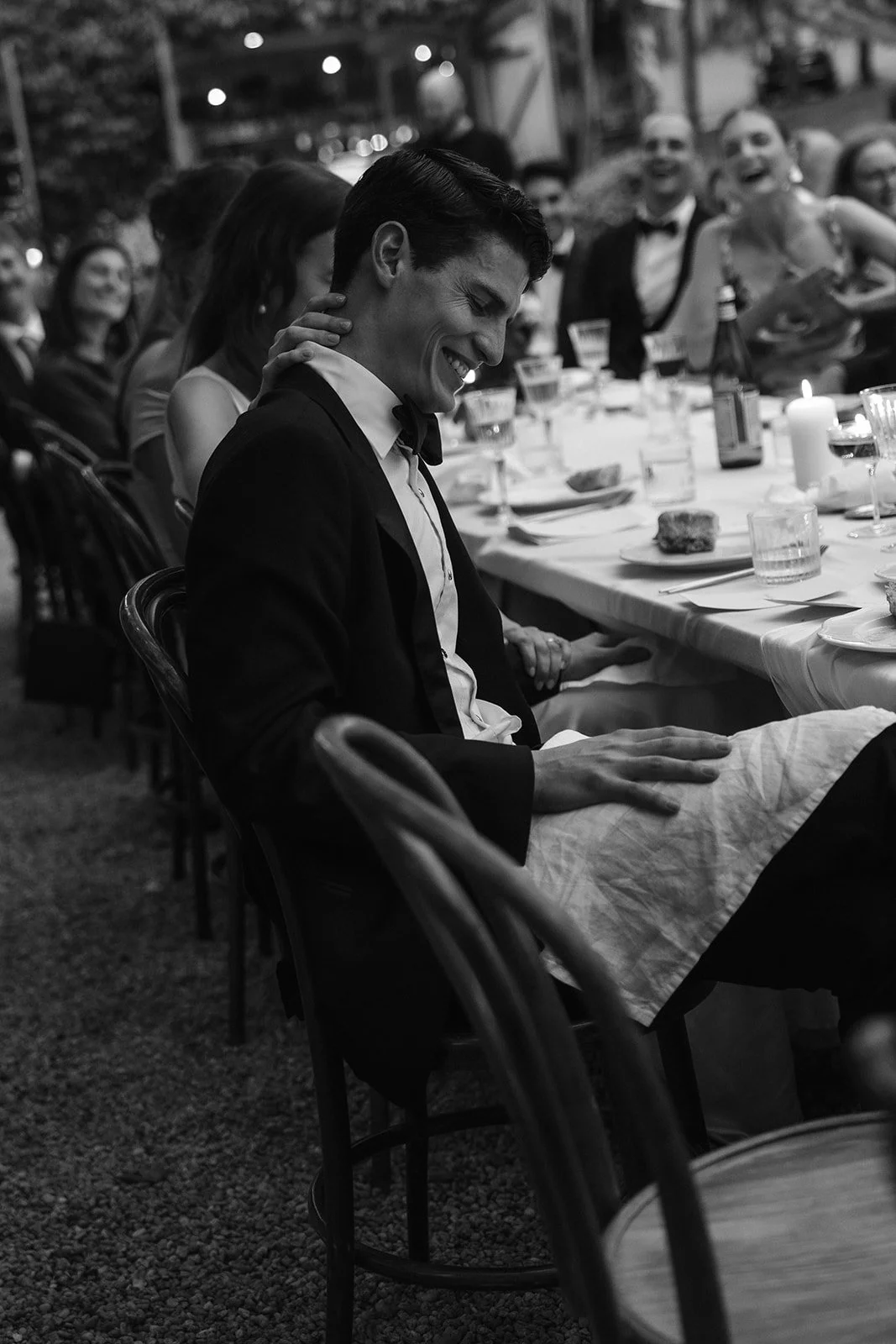 The groom laughing during the evening reception at Krinklewood Estate, as the celebration moved into candlelight.