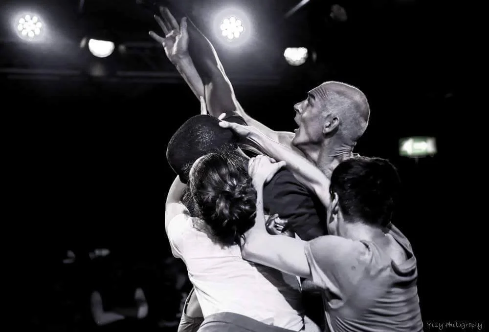 Black and white photo of a physical altercation involving multiple people wrestling or fighting with each other.