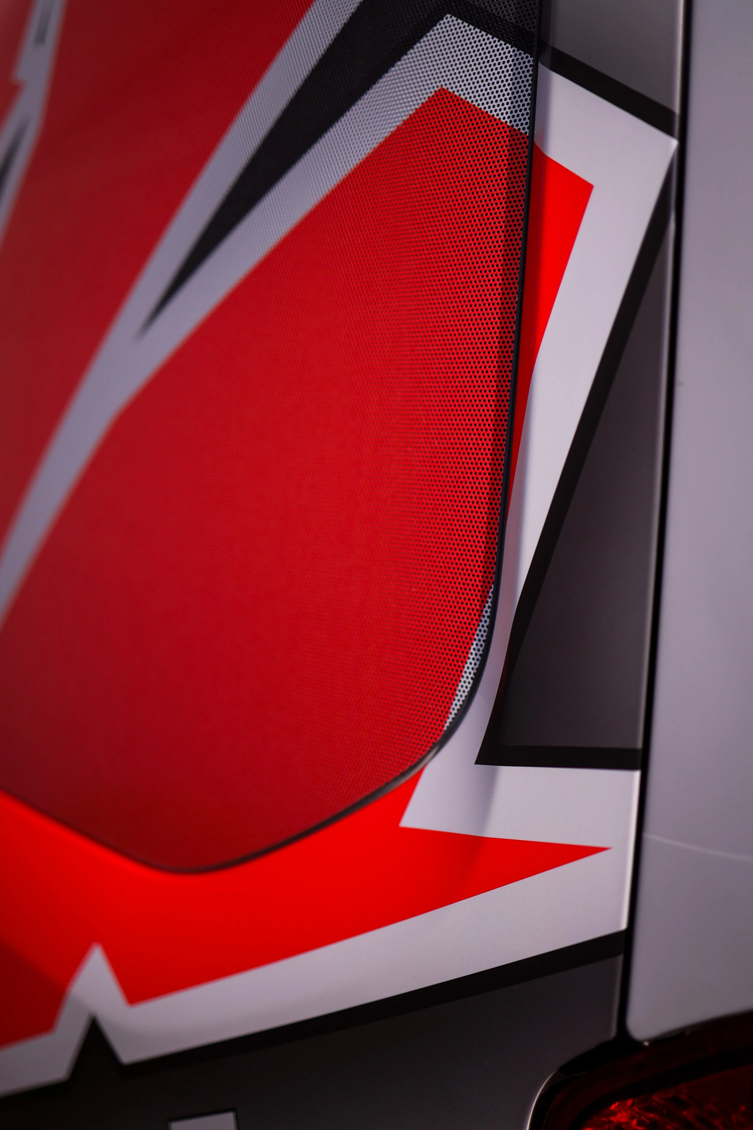 Close-up of a red and black bulletin board with layered paper and graphic design elements.