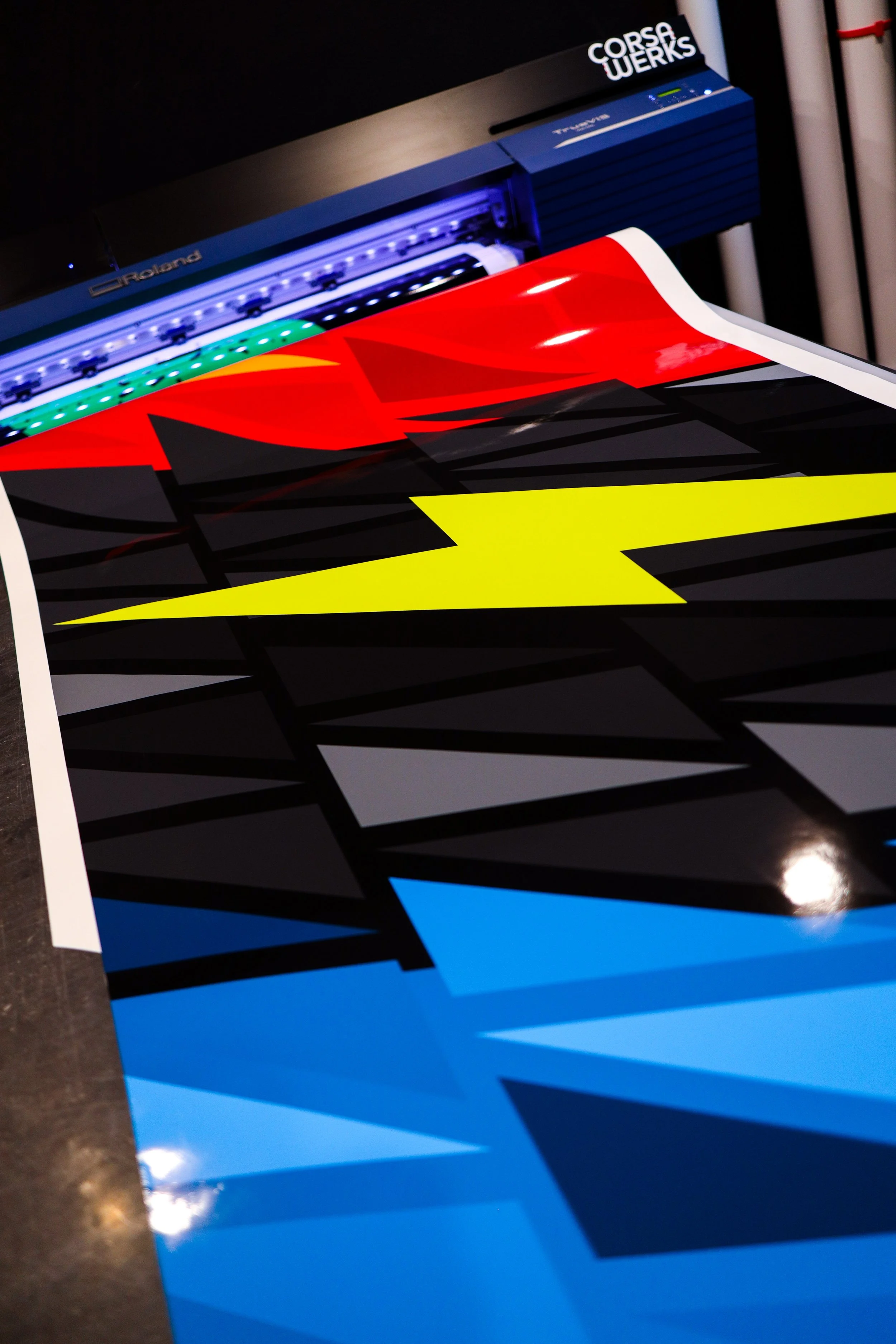 Colorful graphic print being produced by a Roland Corsa WERKS printer.