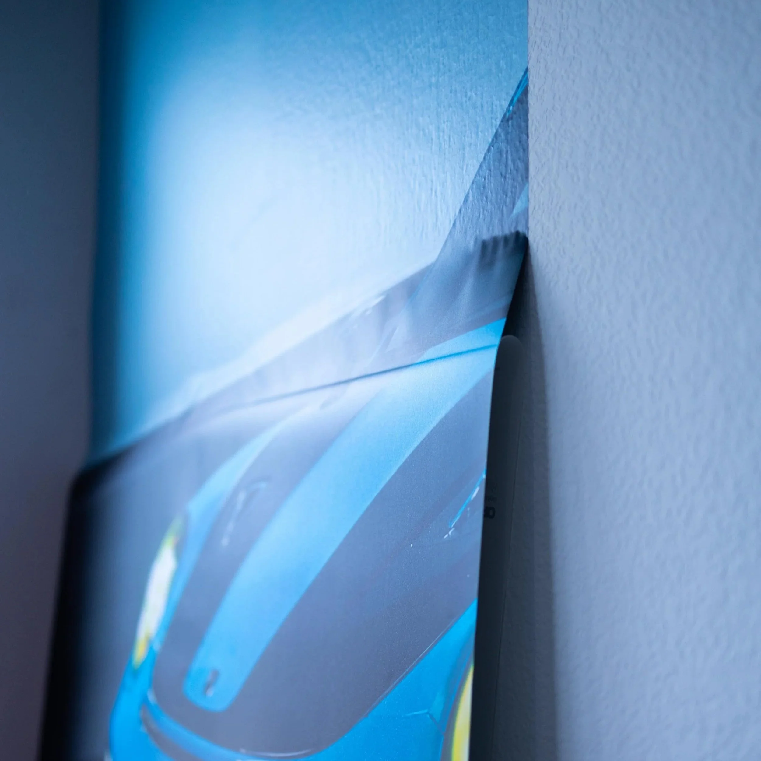 Close-up of a corner of a computer monitor with a protective plastic film being peeled off