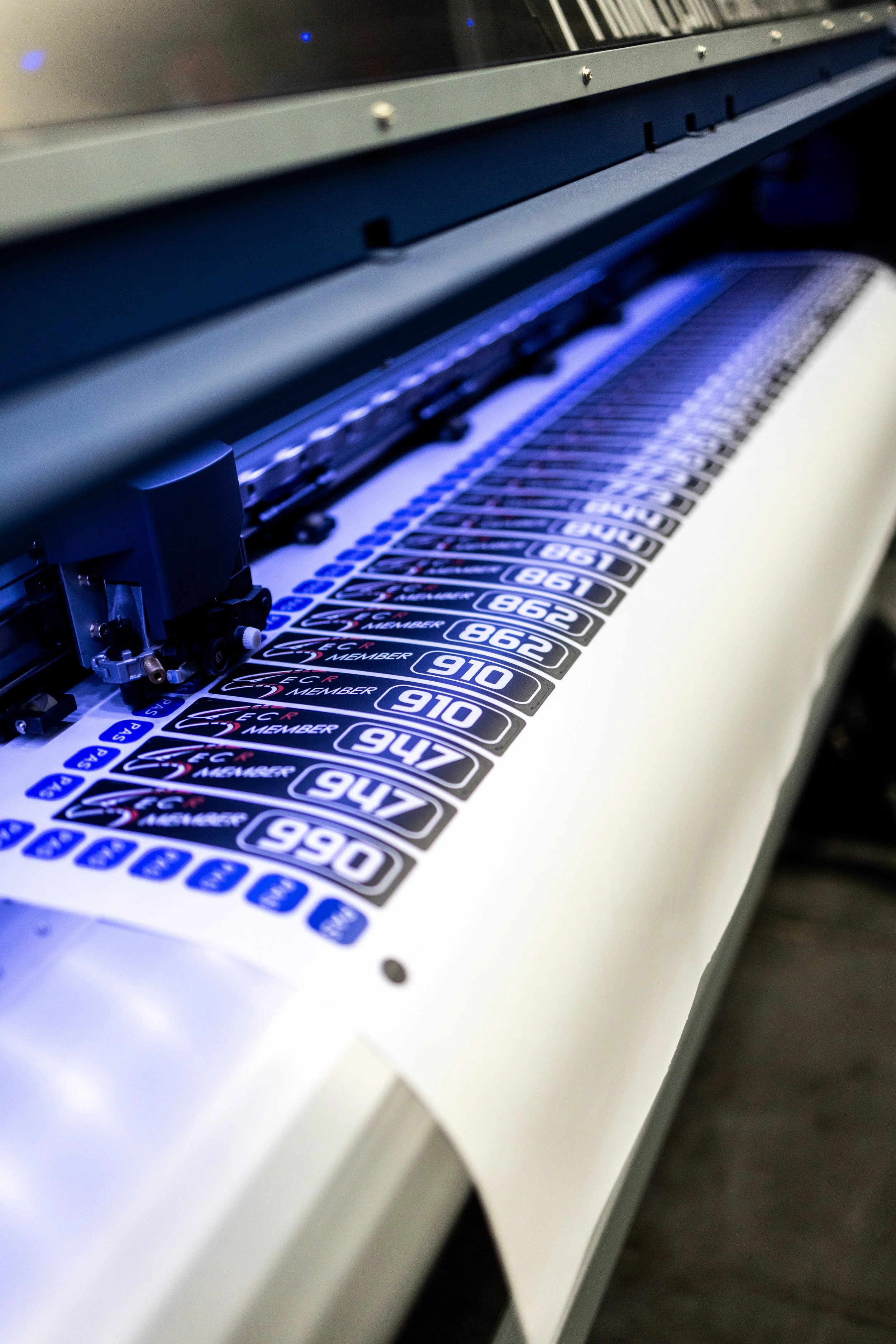 An industrial sticker printing machine printing labels with numbers and text.
