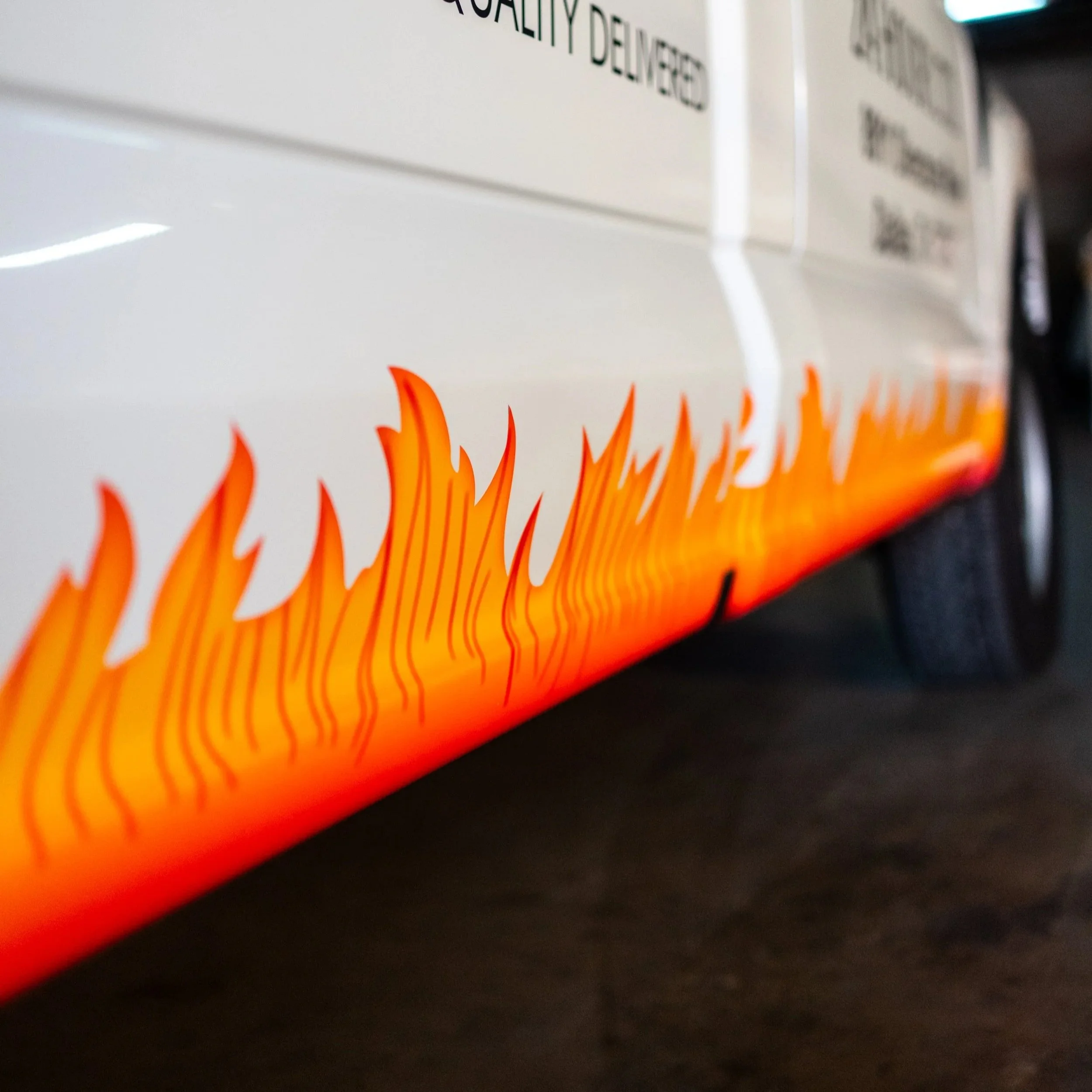 Close-up of a white appliance with orange flame graphics near the bottom.