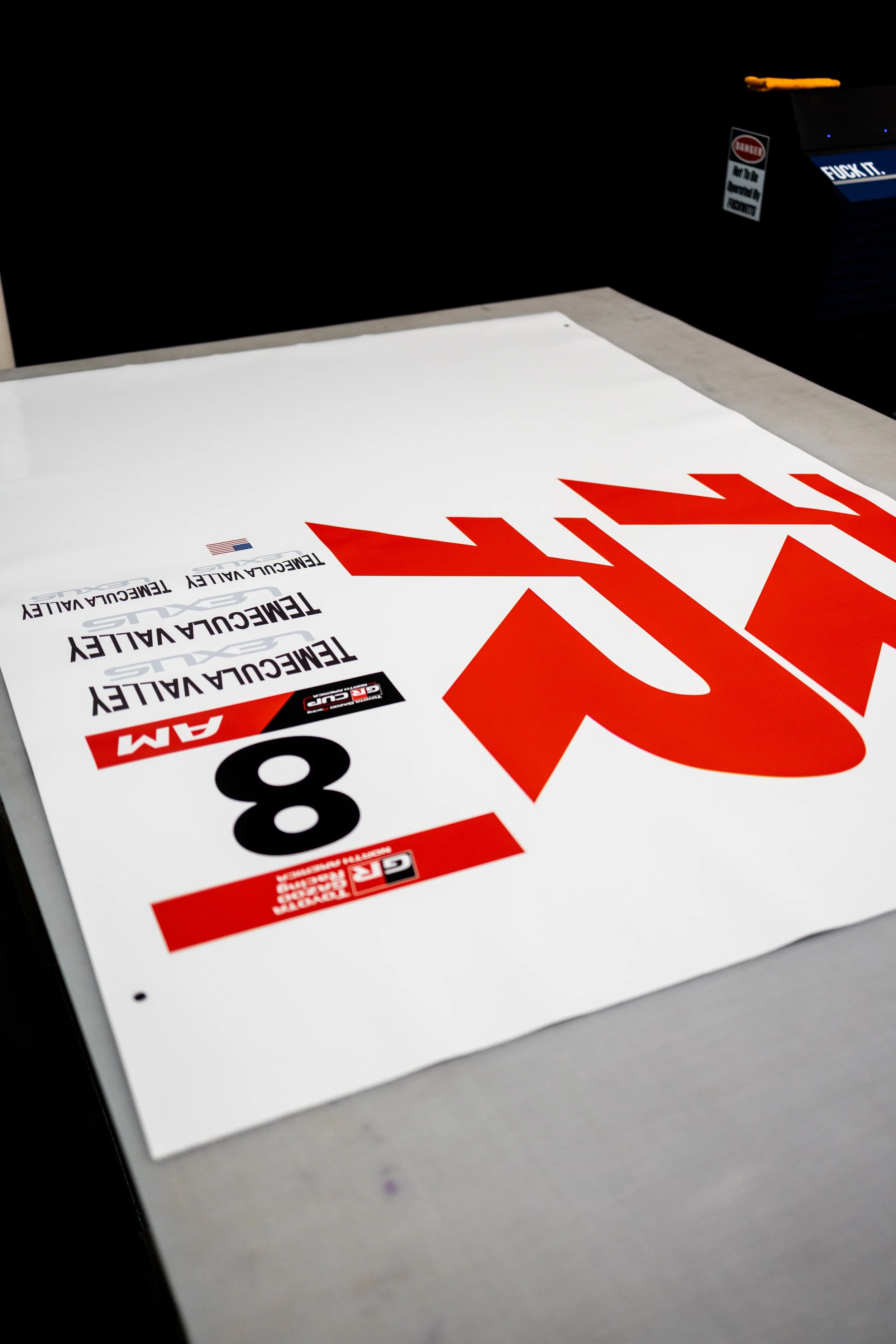 A printed sign for a ticketing event, featuring bold red and black text that says 'Race' and details about the event, including a large number 8 and the words 'TEEMCUULLY' and relevant logos.
