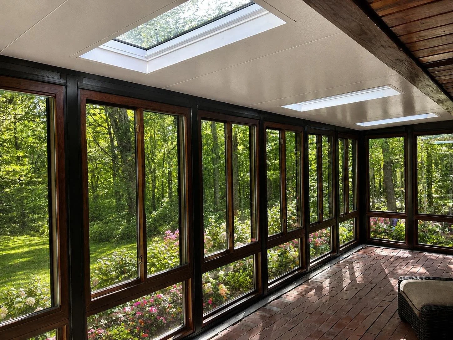 Interior View: Floor-to-ceiling windows and skylights create a peaceful four-season retreat with abundant natural light and views of the surrounding woods.