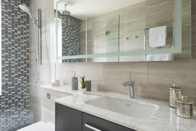 Modern bathroom large mirror, a white sink with a cabinet, a marble countertop, and a glass-enclosed shower with mosaic tile walls. modern house wimbledon terrace