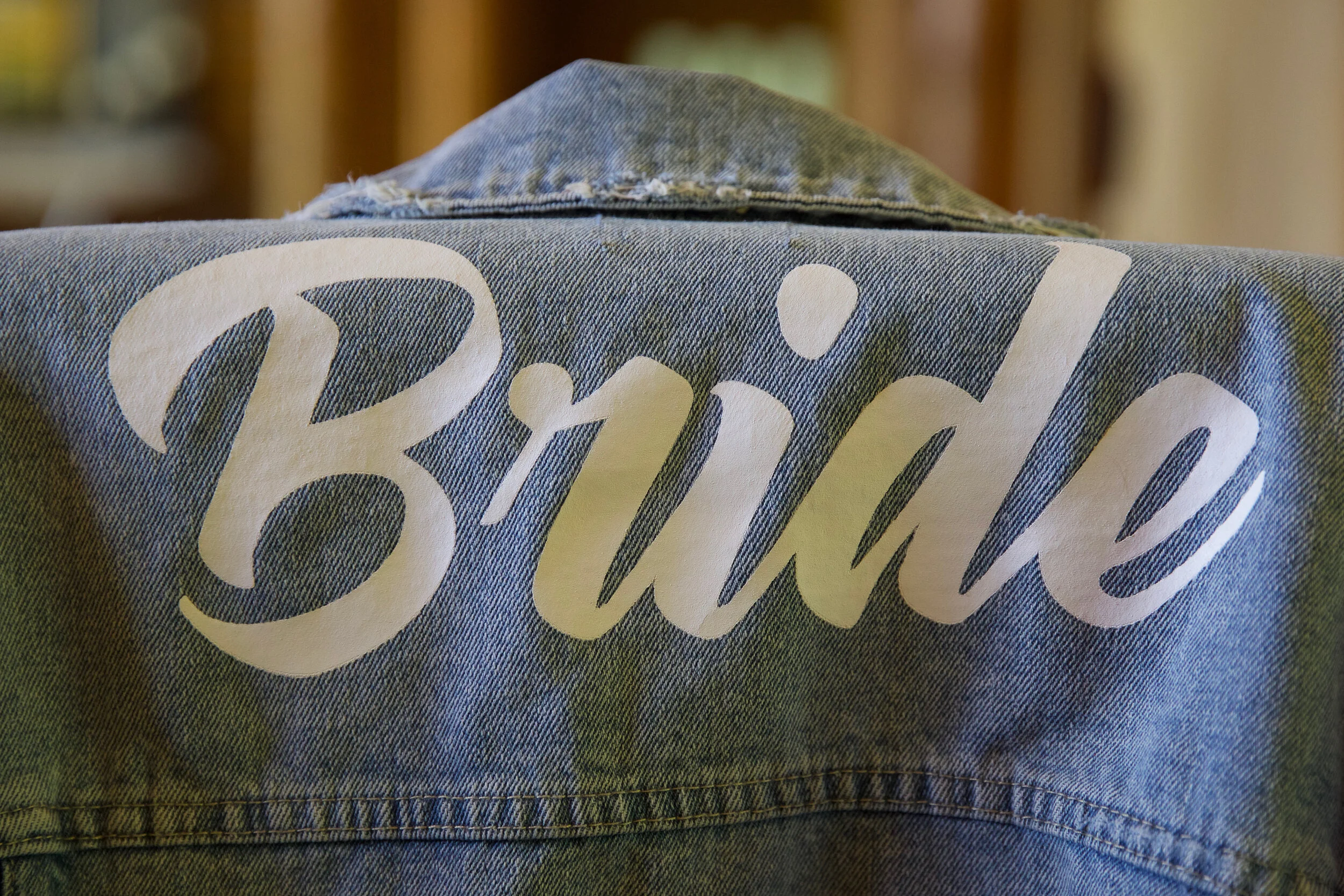 Denim jacket with "Bride" written in white script on the back.