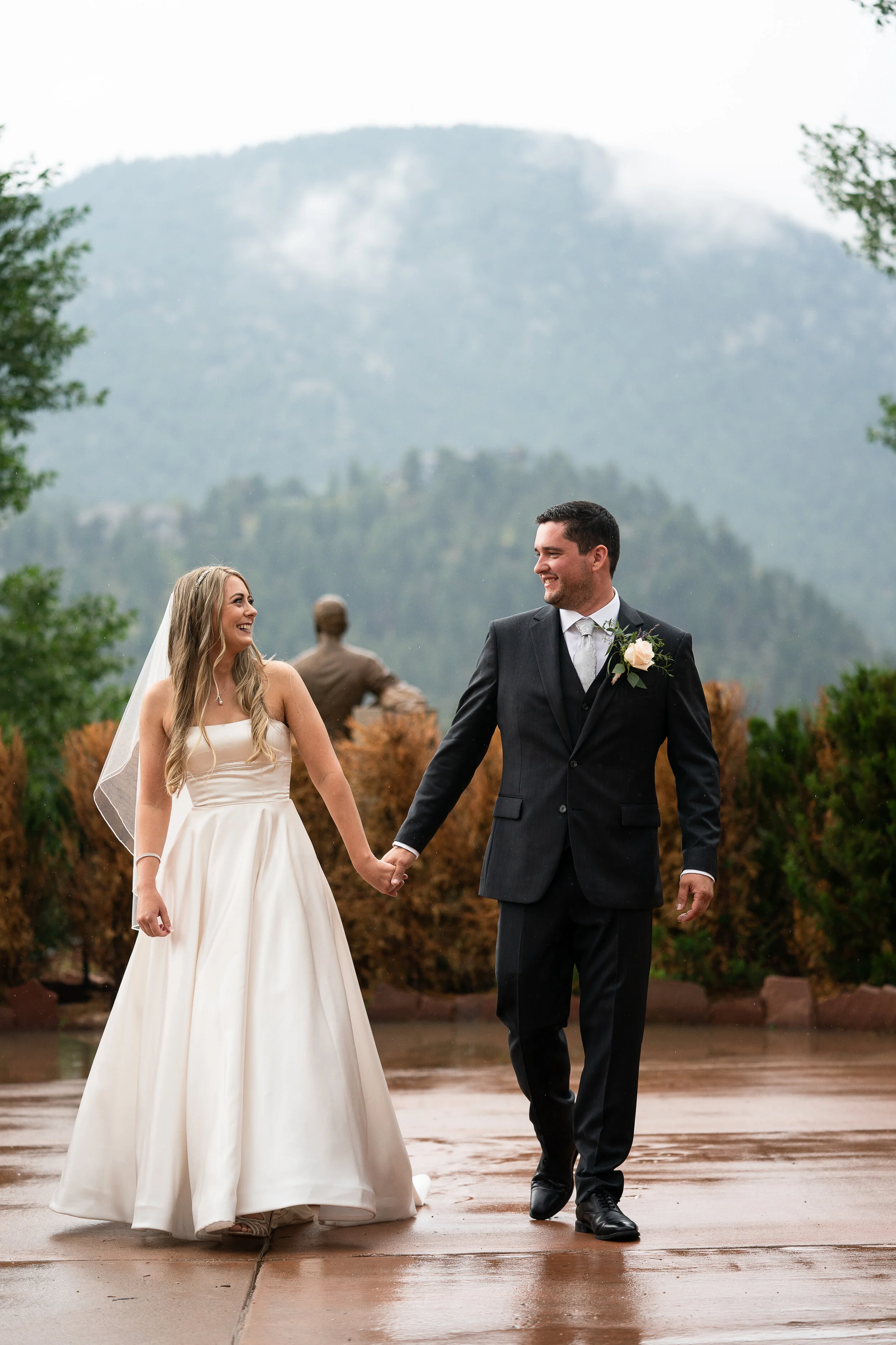 Bride and groom holding hands with a mountain backdrop