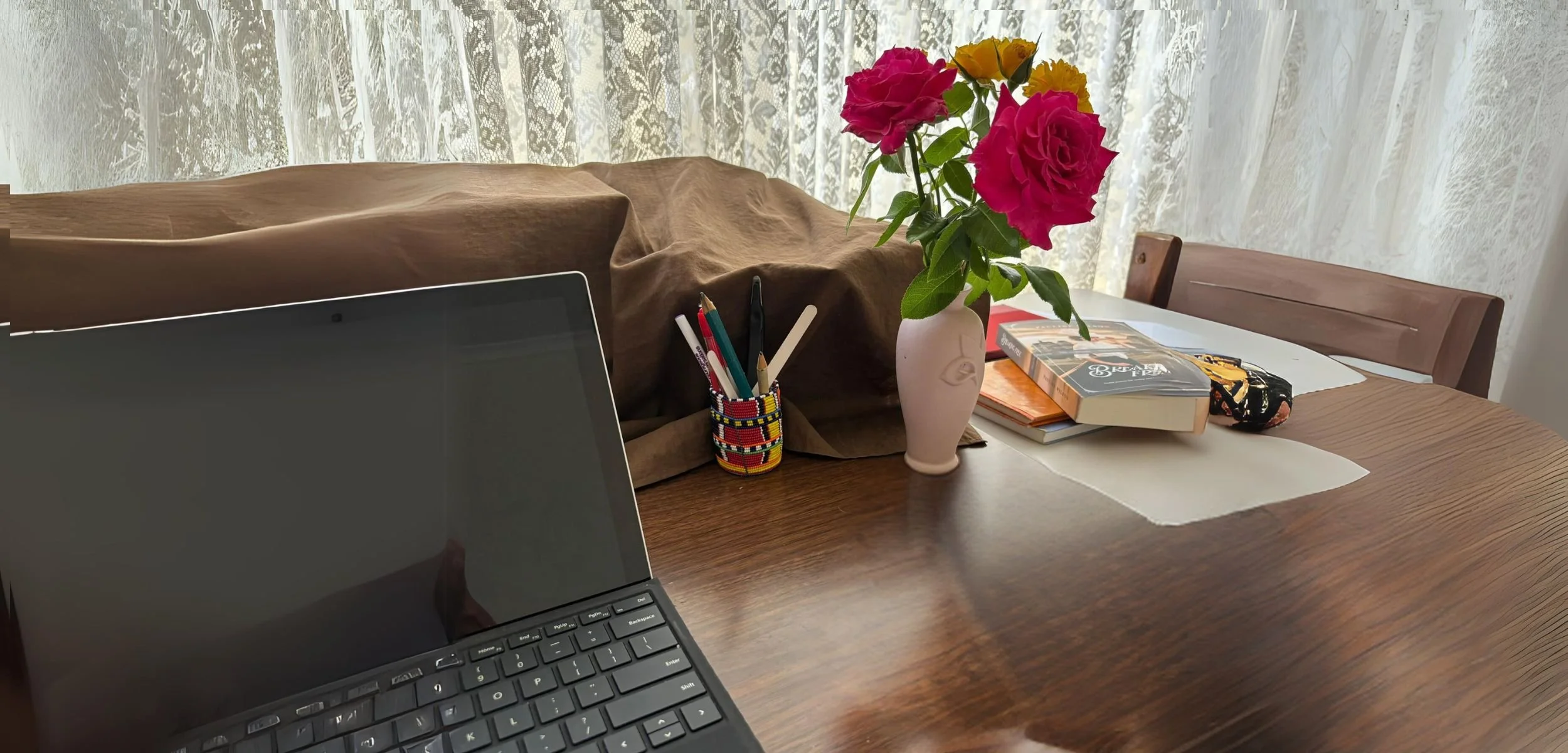 My writing desk with laptop, books and flowers