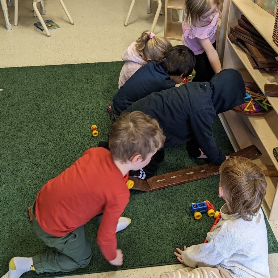 The children in the 4-year-old kindergarten room collaboratively build increasingly complicated ramps during their day. The children work together to build the ramps, suggesting different ways to place the ramps and share observations on how the trac