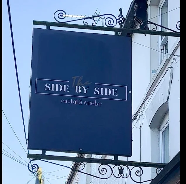 Hanging sign for The side by side Cocktail & Wie Bar