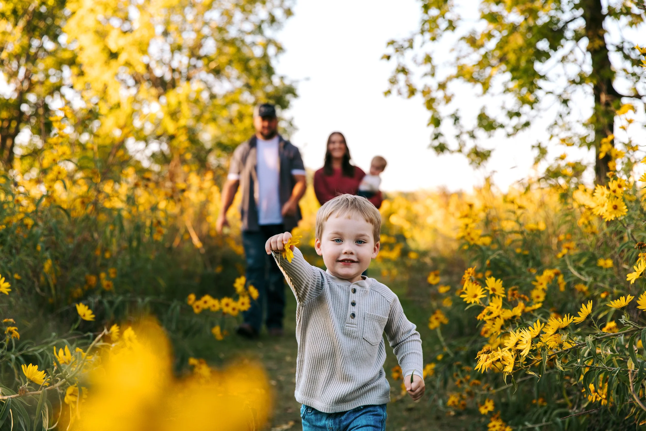 Family walking toward the camera during a stress-free outdoor photo session in Kearney, NE