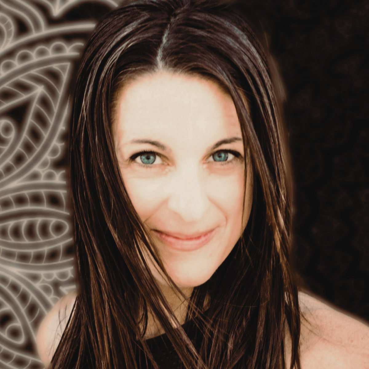 A woman with long brown hair and blue eyes smiling at the camera, with a decorative pattern in the background.