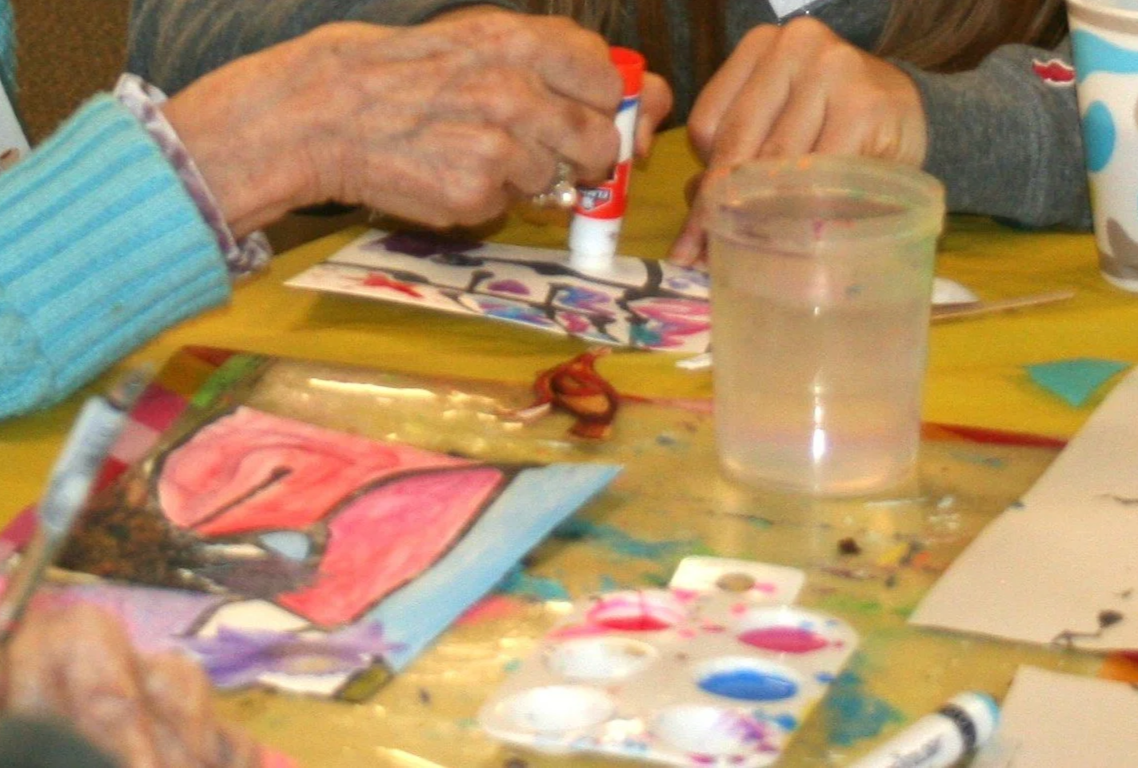 hands of two different people working on one artwork together