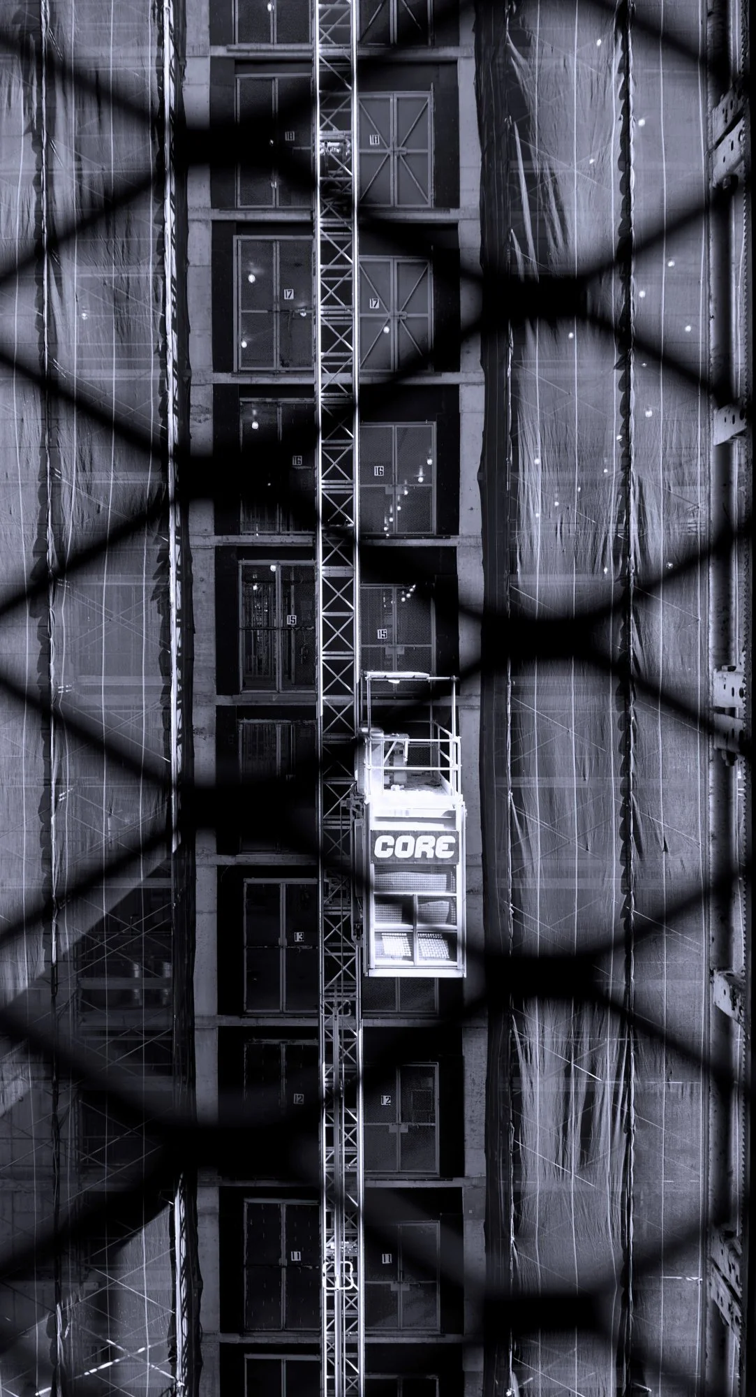 231010.A.02.N.03 - View of One Construction Hoist as Seen from the Gate of Another