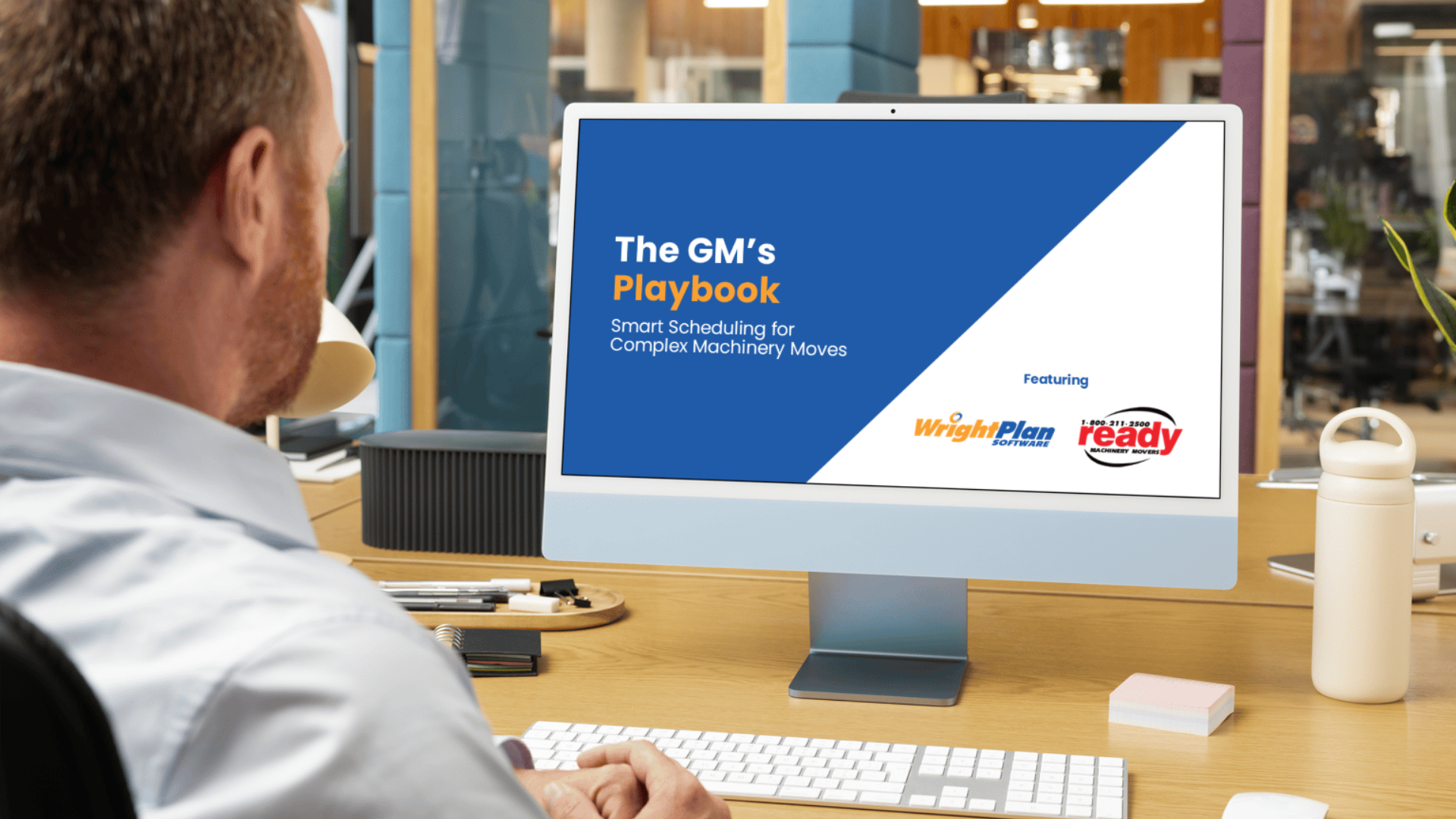 A man sitting at a wooden desk using a computer to view a presentation titled 'The GM's Playbook: Smart Scheduling for Complex Machinery Moves.' The screen displays logos for WrightPlan Software and Machinery Ready.
