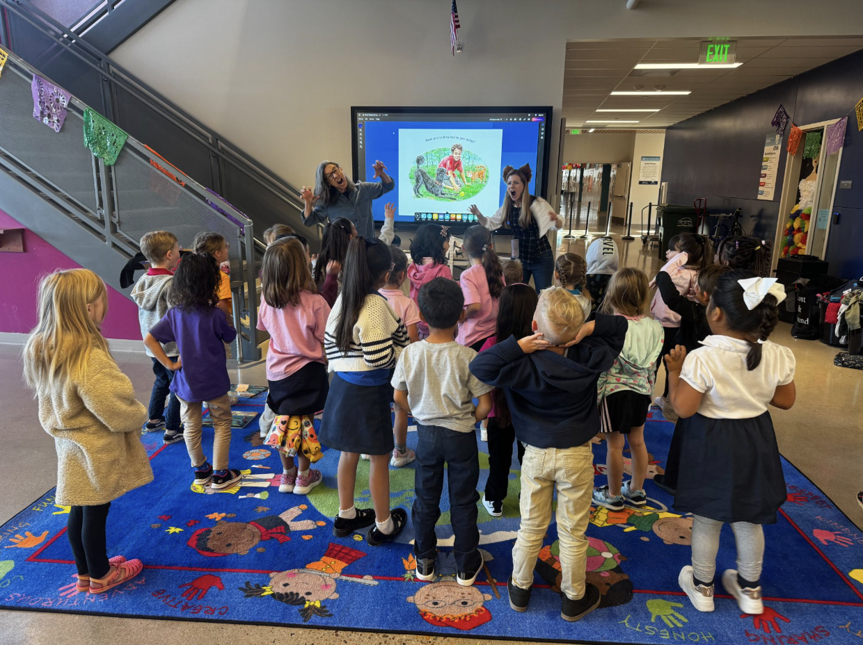 Carolyn and another author act out a story for a group of childrens