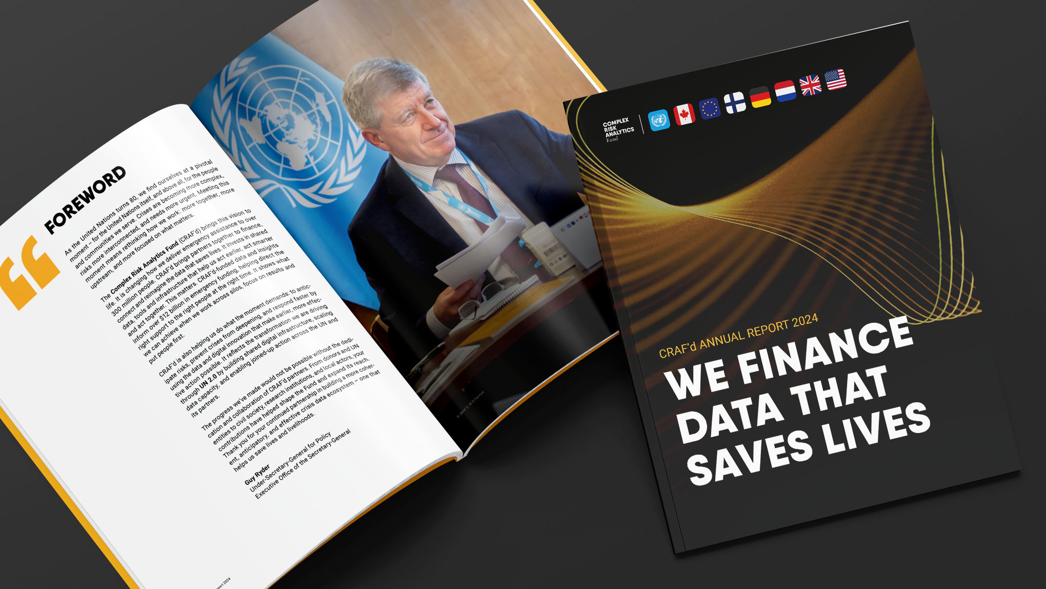 Open annual report booklet with a photograph of a man in a suit speaking at a UN event, United Nations logo, and flags of multiple countries on the cover.