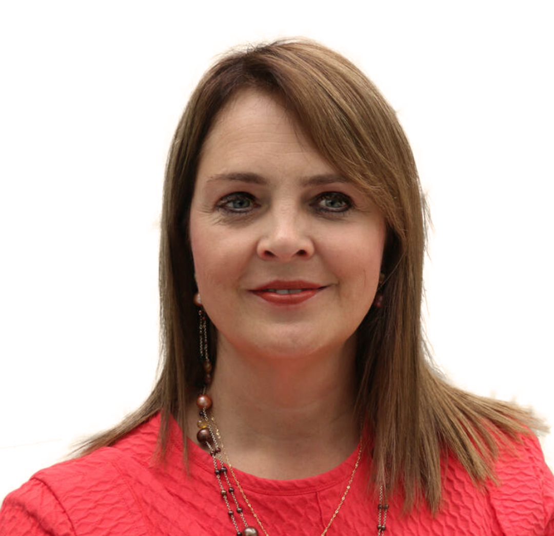 Headshot of a woman with straight brown hair, wearing a red textured top and layered necklaces against a white background.