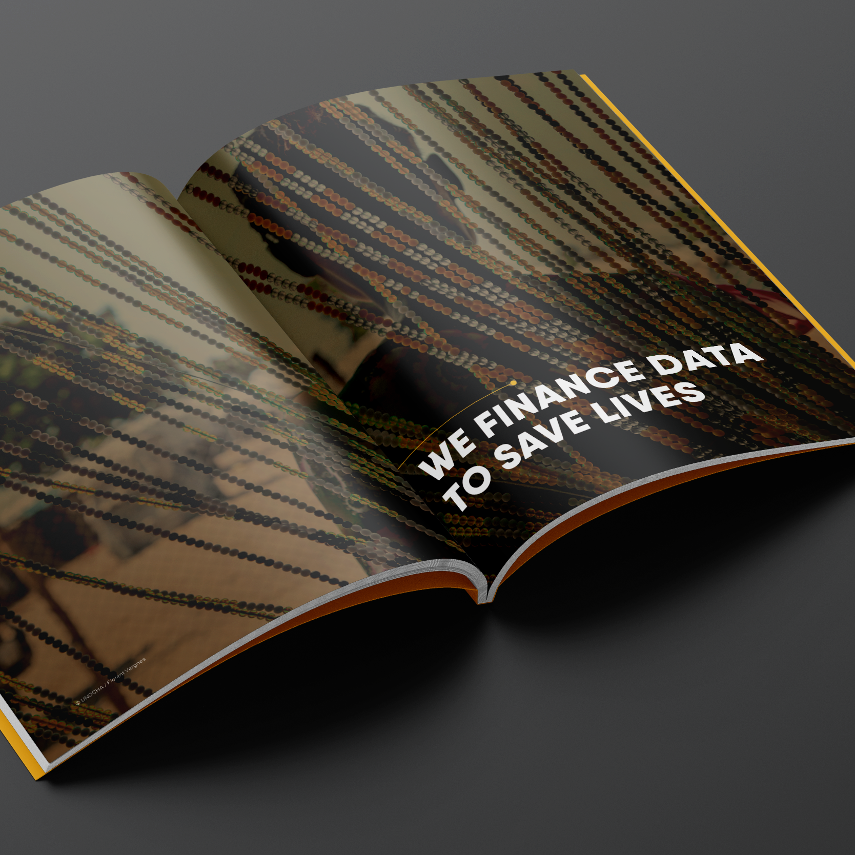 An open magazine featuring a dark background with the text "WE FINANCE DATA TO SAVE LIVES" in bold white letters.