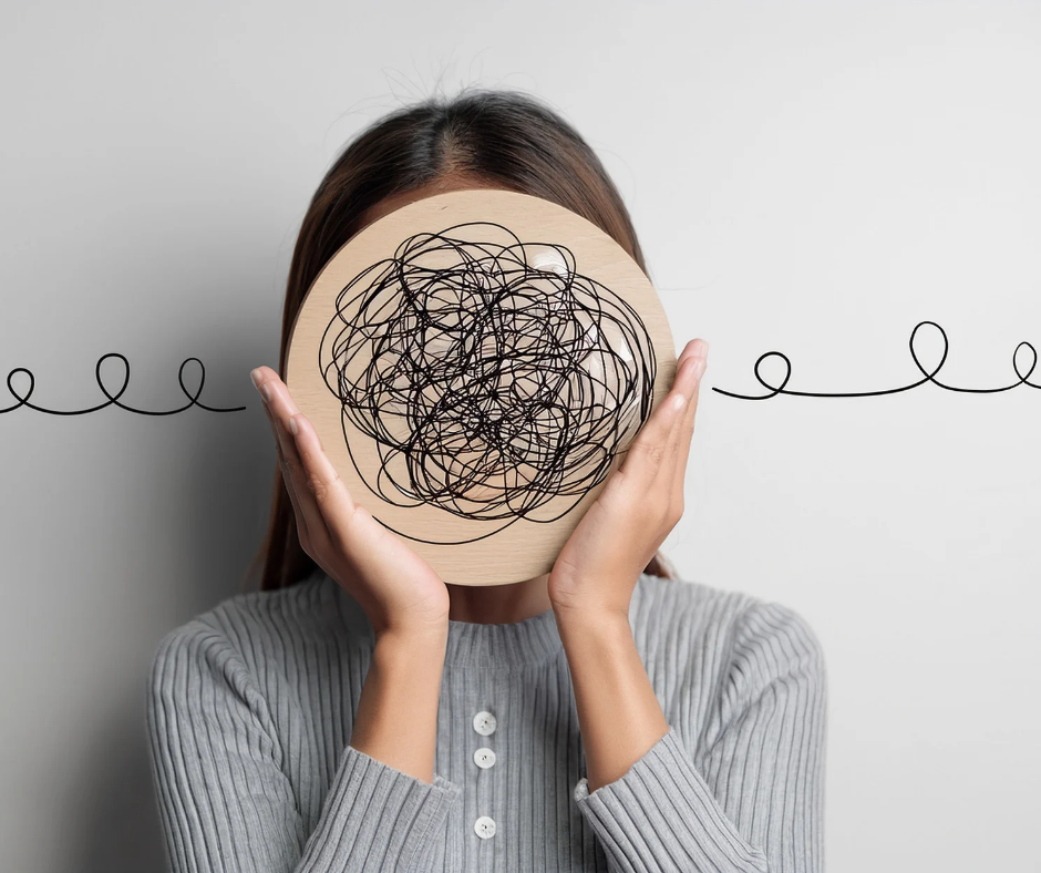 girl holding squiggly drawing in front of face