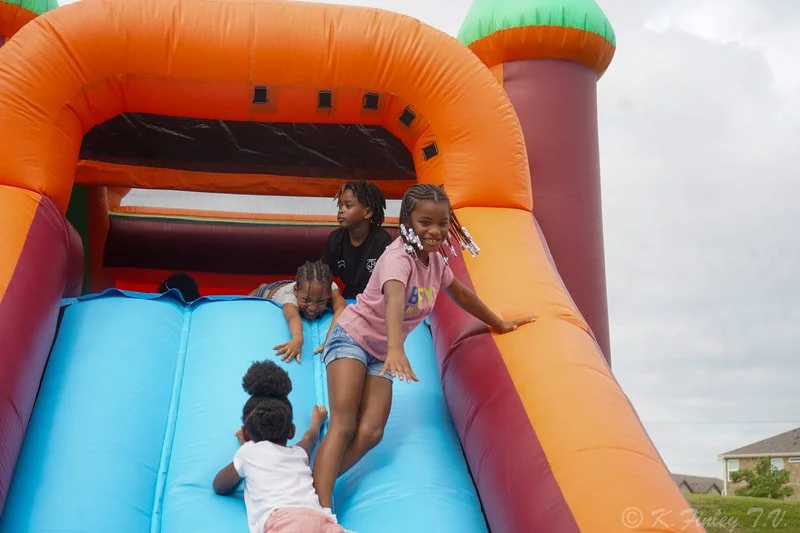 Children playing on a colorful inflatable slide outdoors