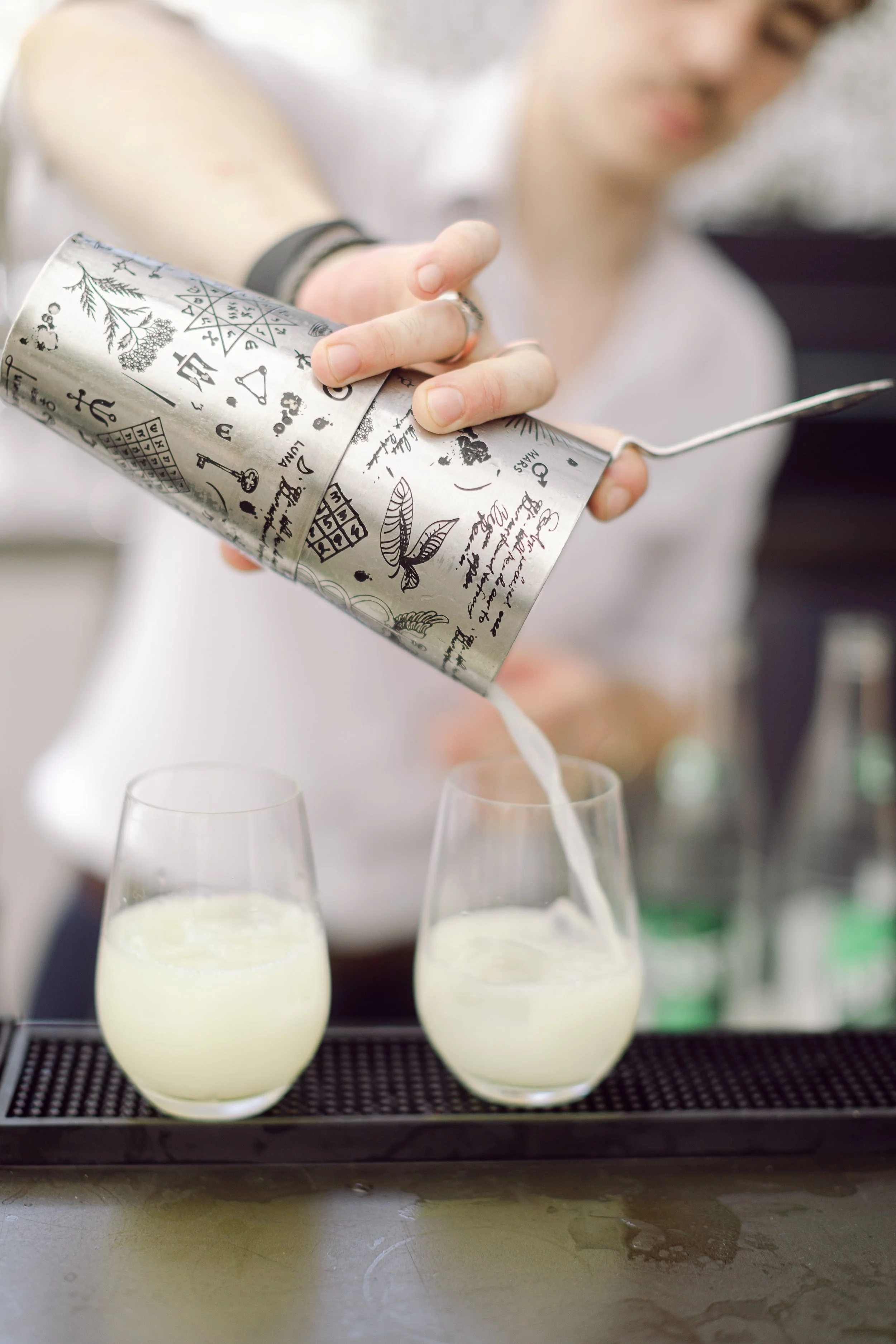 Professional bartender preparing zero-proof cocktails, showcasing skill and creativity at a high-end event.
