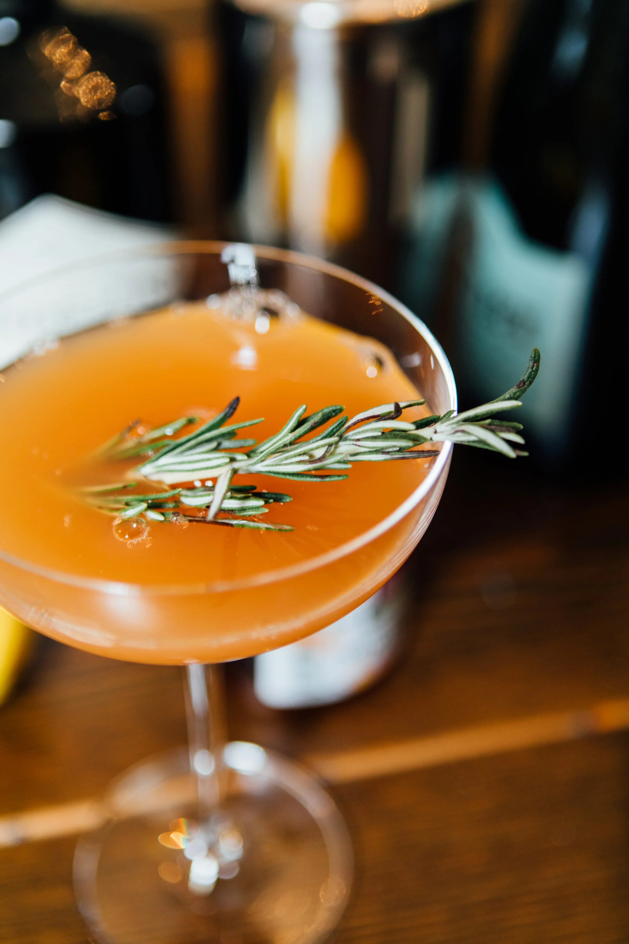 Signature holiday cocktail with cranberry and rosemary garnish