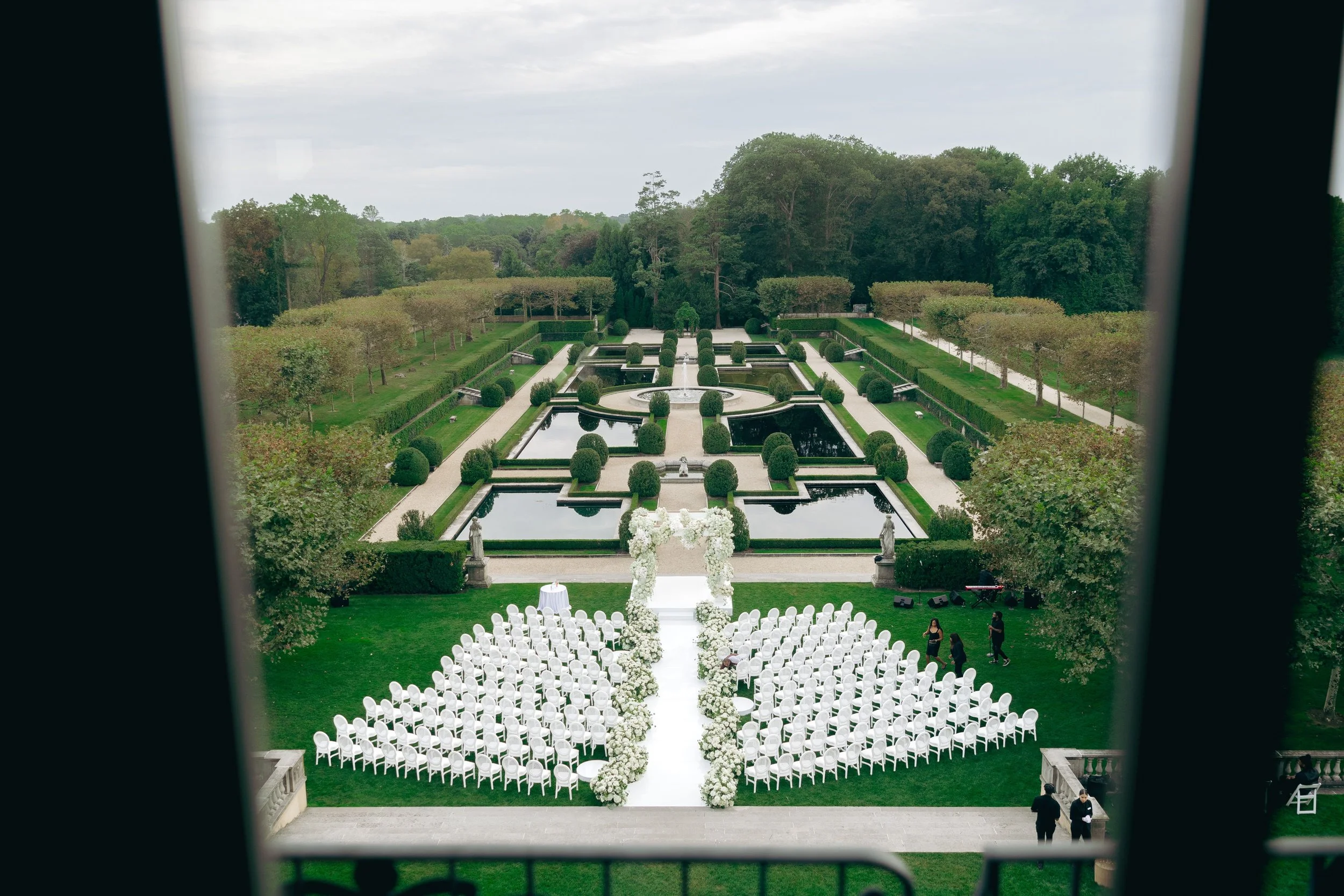 Bespoke wedding floral and design featuring a focal ceremony structure design, aisle floral arrangements, candlelight and curated ceremony details.